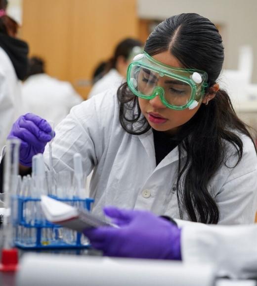 A close up image of a chemistry lab student working in the lab. 