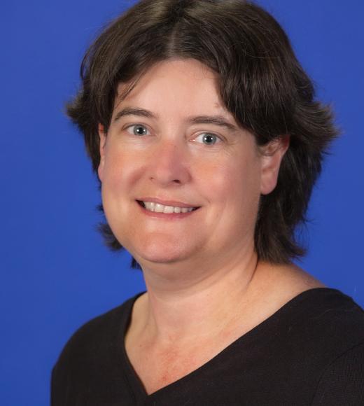 Smiling woman with short brown hair in black top